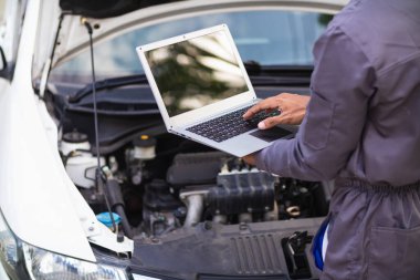 Araç hizmet merkezi tamircileri araba ve motoru kontrol ediyor. Kullanıma hazır ve merkezin garantisine göre mükemmel durumda olduklarından emin olun. Güvenli sürüş için periyodik araç denetimleri.