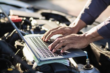 Araç hizmet merkezi tamircileri araba ve motoru kontrol ediyor. Kullanıma hazır ve merkezin garantisine göre mükemmel durumda olduklarından emin olun. Güvenli sürüş için periyodik araç denetimleri.