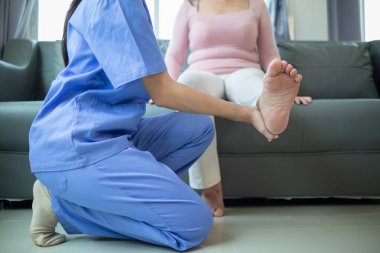 Kadın doktor, kas yaralanmasından sonra kaslarının iyileşmesine yardım ediyor ve günlük yaşamını sürekli fizik tedaviyle devam ettirebilmesi için onu rehabilite etmek istiyor..