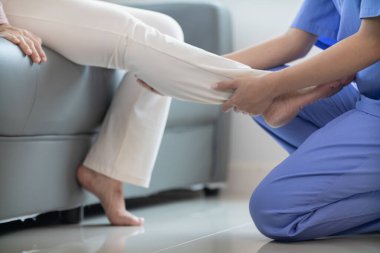 Kadın doktor, kas yaralanmasından sonra kaslarının iyileşmesine yardım ediyor ve günlük yaşamını sürekli fizik tedaviyle devam ettirebilmesi için onu rehabilite etmek istiyor..