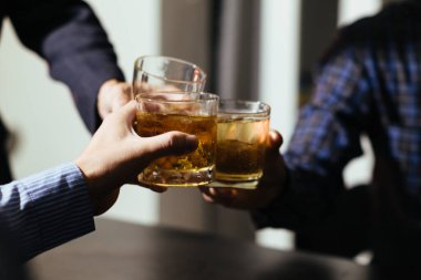 Bir grup işadamı brendi bardaklarını bir arada tutarak, ticari girişimler ve ortak iş karları konusunda tatmin edici bir anlaşmaya vardıktan sonra brendi kadehlerini bir araya getirdi..