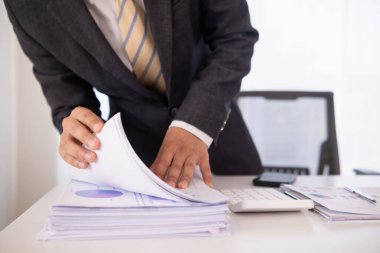 Sekreterin şirket yönetim kurulu ve yatırımcılarının toplantıları için hazırladığı bir yığın belge. Birçok belge düzenlendi ve sekreterlik bürosundaki masanın üzerine yığıldı.