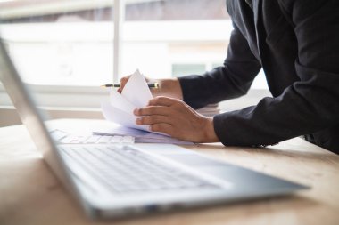 Sekreterin şirket yönetim kurulu ve yatırımcılarının toplantıları için hazırladığı bir yığın belge. Birçok belge düzenlendi ve sekreterlik bürosundaki masanın üzerine yığıldı.