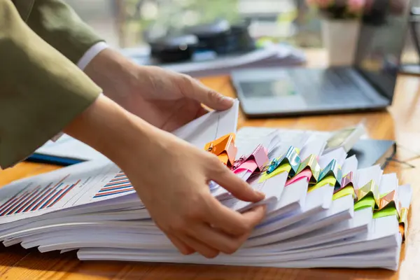 stock image pile of documents sat on desk in office was pile of documents that had been prepared to be presented at meeting as summary of annual operations. Documents prepared for storage and piled on the desk.