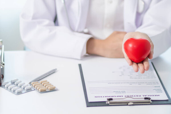 Символ красного сердца в руке врача является символом кампании по уходу за здоровьем пациентов с сердечными заболеваниями и поощряет людей, подверженных риску сердечных заболеваний, приходить на регулярные осмотры.