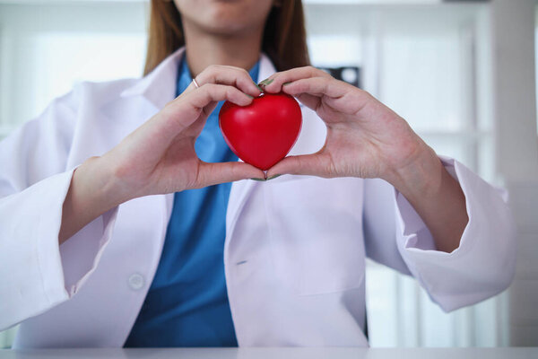 The red heart symbol in the doctor's hand is a symbol of the campaign to care for the health of heart disease patients and encourage people at risk of heart disease to come for regular check-ups.
