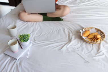 Kadın, öğretmeninden aldığı ders kitaplarından ders almak ve anlamak için çevrimiçi bir ders sırasında bilgi aramak için dizüstü bilgisayar kullanıyor. Çevrimiçi öğrenme kavramı dersleri öğrenmek ve gözden geçirmek için.