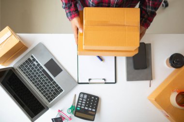 Evlerini ofis olarak kullanan ve çevrimiçi uygulamalar yoluyla ürün satan küçük KOBİ girişimcileri, siparişleri karşılamak için yeterli olup olmadıklarını kontrol ediyorlar..