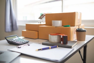 paket kutuları paketleniyor ve çevrimiçi mağazanın sistemine çevrimiçi siparişler koyan müşterilere gönderilmeye hazır. Küçük bir KOBİ işadamı paketleri hazırladı ve teslimata hazır.