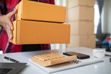 paket kutuları paketleniyor ve çevrimiçi mağazanın sistemine çevrimiçi siparişler koyan müşterilere gönderilmeye hazır. Küçük bir KOBİ işadamı paketleri hazırladı ve teslimata hazır.