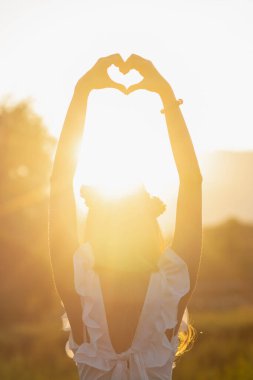 Genç bir kadın, sevgilisine ve arkadaşına şefkat ve dostluğu sembolize etmek için başına kalp şeklinde bir el koyar. Çünkü kalp, sevgi, dostluk ve merhameti simgeler..