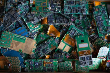 Fabrika zeminindeki elektronik atık yığını, işlenmeyi bekleyen bir devre telefon levhası. Değerli metali elektronik atıktan ayırmak için altın çıkarmayı bekliyor. Değerli metali e-atıktan çıkarmak