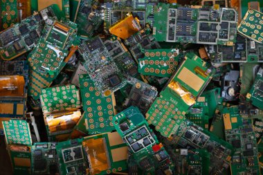 Fabrika zeminindeki elektronik atık yığını, işlenmeyi bekleyen bir devre telefon levhası. Değerli metali elektronik atıktan ayırmak için altın çıkarmayı bekliyor. Değerli metali e-atıktan çıkarmak