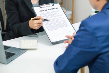 Emlakçı, emlak bürosundaki şirket projesinde emlak alım ve satımının terfisini sunmak için müşteriyle konuşuyor. Satın almaya karar vermek için mevcut promosyon.