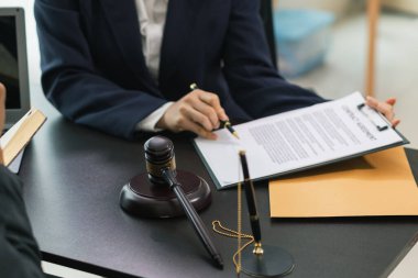 Yargıç Tokmak, avukat ekibinin masasına oturtulmuştur. Bu tokmak, mahkemede adalet ve etik çerçevesinde karar vermenin sembolü olarak kullanılır. Yargıç Tokmak, mahkeme kararını sembolize ediyor..