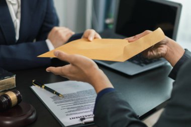 Avukatlar hukuk bürosunda oturup, iş yatırımlarındaki hataları önlemek için hukuki konularda yardıma ihtiyacı olan müşterilere tavsiye vermeyi bekliyorlar. Avukatlardan oluşan bir ekipten hukuki tavsiye alma kavramı.