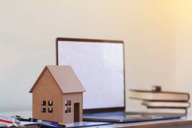 Model ev, mühendislerin ve tasarımcıların masalarının üzerinde yatırımcıları tasarımlarıyla memnun etmek için durur. Emlak yatırımcısını memnun etmek için mimarların ev tasarımı fikirleri.