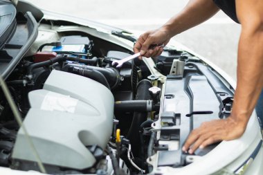 Araç hizmet merkezi tamircileri araba ve motoru kontrol ediyor. Kullanıma hazır ve merkezin garantisine göre mükemmel durumda olduklarından emin olun. Güvenli sürüş için periyodik araç denetimleri.