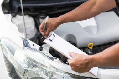 Araç hizmet merkezi tamircileri araba ve motoru kontrol ediyor. Kullanıma hazır ve merkezin garantisine göre mükemmel durumda olduklarından emin olun. Güvenli sürüş için periyodik araç denetimleri.