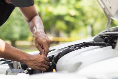 Araç hizmet merkezi tamircileri araba ve motoru kontrol ediyor. Kullanıma hazır ve merkezin garantisine göre mükemmel durumda olduklarından emin olun. Güvenli sürüş için periyodik araç denetimleri.