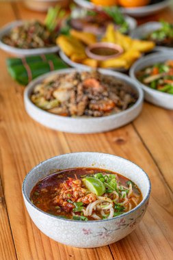 Khao Soi Chiang Tung bir kase içinde pilav eriştesi ve Chiang Tung usulü lezzetli bir çorba ile servis edilir. Lezzetli Khao Soi Chiang Tung, Tai Yai halkı arasında popüler bir erişte yemeği..