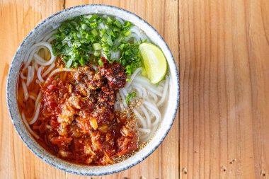 Khao Soi Chiang Tung bir kase içinde pilav eriştesi ve Chiang Tung usulü lezzetli bir çorba ile servis edilir. Lezzetli Khao Soi Chiang Tung, Tai Yai halkı arasında popüler bir erişte yemeği..