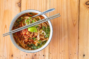 Khao Soi Chiang Tung bir kase içinde pilav eriştesi ve Chiang Tung usulü lezzetli bir çorba ile servis edilir. Lezzetli Khao Soi Chiang Tung, Tai Yai halkı arasında popüler bir erişte yemeği..