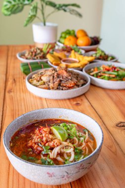 Khao Soi Chiang Tung bir kase içinde pilav eriştesi ve Chiang Tung usulü lezzetli bir çorba ile servis edilir. Lezzetli Khao Soi Chiang Tung, Tai Yai halkı arasında popüler bir erişte yemeği..