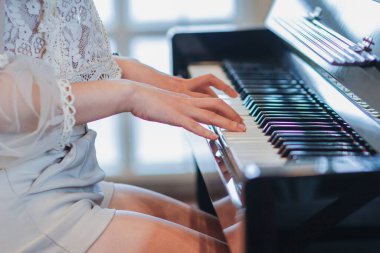 Soft Focus ve Smooth Focus, genç bir piyanist piyano performansı için pratik yapıyor. Klavyede dinlenen kadın bir piyanistin elleri sahnede piyano çalıyor..
