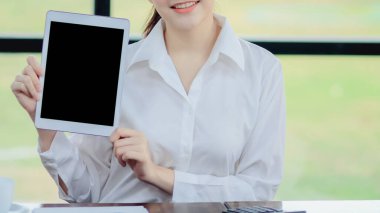 Genç kadın internette bilgi aramak için elinde bir tablet kullanıyor ve ihtiyacı olduğunda gerekli bilgiyi aramasını kolaylaştırmak için tableti nasıl kullanacağını öğreniyor..