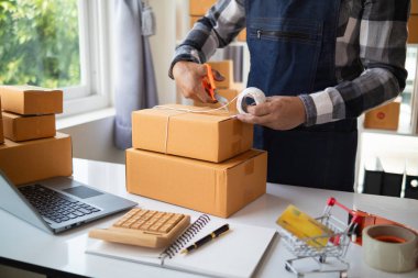 KOBİ işletmelerini işleten girişimciler, müşterilere nakliyeye hazır olmak için kutu ve paketlerde ürünler hazırlıyorlar. Ürünler kutuda ve paketlerde nakliyeye hazırlanıyor.