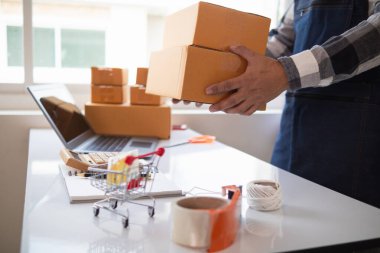 KOBİ işletmelerini işleten girişimciler, müşterilere nakliyeye hazır olmak için kutu ve paketlerde ürünler hazırlıyorlar. Ürünler kutuda ve paketlerde nakliyeye hazırlanıyor.