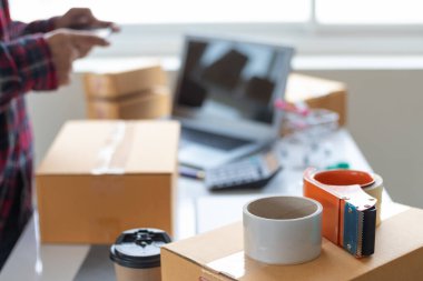 KOBİ işletmelerini işleten girişimciler, müşterilere nakliyeye hazır olmak için kutu ve paketlerde ürünler hazırlıyorlar. Ürünler kutuda ve paketlerde nakliyeye hazırlanıyor.