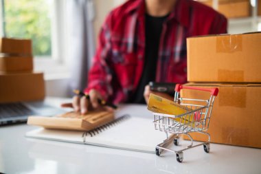 KOBİ işletmelerini işleten girişimciler, müşterilere nakliyeye hazır olmak için kutu ve paketlerde ürünler hazırlıyorlar. Ürünler kutuda ve paketlerde nakliyeye hazırlanıyor.