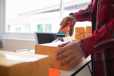 KOBİ işletmelerini işleten girişimciler, müşterilere nakliyeye hazır olmak için kutu ve paketlerde ürünler hazırlıyorlar. Ürünler kutuda ve paketlerde nakliyeye hazırlanıyor.