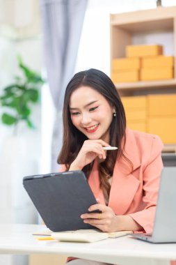 KOBİ işini yürüten ve güvenilir lojistik yoluyla hisse senedi hazırlayan iş kadını ve çevrimiçi medya aracılığıyla dükkanı tanıtarak satışları teşvik eden çevrimiçi başvuru yoluyla siparişler alıyor