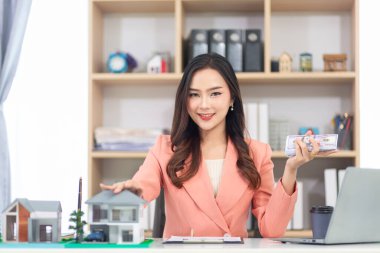 Emlakçı, müşteri emlak sözleşmesi imzaladığında evi korumak için sigorta teklif ediyor. Emlakçı olan işadamı, müşteri sözleşmesi imzalarken sigorta terfisi teklif ediyor.