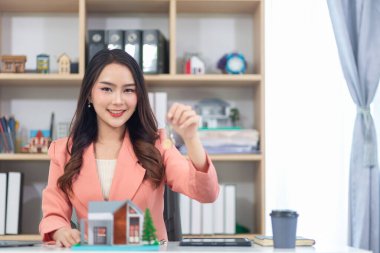 Asyalı iş kadını bir emlak komisyoncusu işletiyor ve büyük projeler için potansiyel alıcılara emlak mülklerini teklif ediyor ve emlak endüstrisi nüfusla birlikte büyümeye devam ediyor..