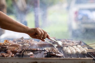Izgara et kömür sobasında çeşitli malzemelerle kızartılır. Et ve çeşitli malzemeler kömür ocağında ızgara olarak pişiriliyor. Arkadaşların kamp yaparken biftek ve barbekü olarak pişiriliyor.