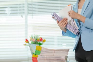 Masadaki belge yığınından önemli kontrat belgeleri arayan işadamı bir yatırımcıyla anlaşma imzaladığını doğruladı. İş adamı kontratta imzaladığı belgelerin doğruluğunu kontrol ediyor.