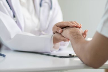 Hastanın elinin üzerinde steteskop olan doktor eli..