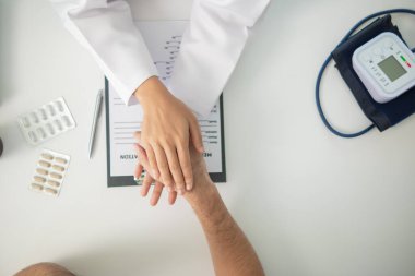 Doktor hastanın elini muayene ediyor.