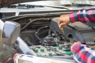 Adam uzun mesafeler kat etmeden önce düzgün ve güvenli bir şekilde tamir etmek için aracın motorunu ve durumunu kontrol ediyor. Adam güvenli bir yere gitmeden önce arabanın ve motorun durumunu kontrol ediyor..