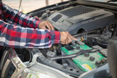 Araç hizmet merkezi tamircileri araba ve motoru kontrol ediyor. Kullanıma hazır ve merkezin garantisine göre mükemmel durumda olduklarından emin olun. Güvenli sürüş için periyodik araç denetimleri.