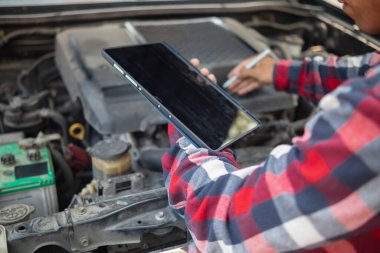 Adam uzun mesafeler kat etmeden önce düzgün ve güvenli bir şekilde tamir etmek için aracın motorunu ve durumunu kontrol ediyor. Adam güvenli bir yere gitmeden önce arabanın ve motorun durumunu kontrol ediyor..