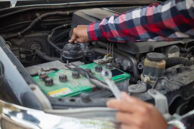 Adam uzun mesafeler kat etmeden önce düzgün ve güvenli bir şekilde tamir etmek için aracın motorunu ve durumunu kontrol ediyor. Adam güvenli bir yere gitmeden önce arabanın ve motorun durumunu kontrol ediyor..