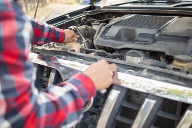 Araç hizmet merkezi tamircileri araba ve motoru kontrol ediyor. Kullanıma hazır ve merkezin garantisine göre mükemmel durumda olduklarından emin olun. Güvenli sürüş için periyodik araç denetimleri.