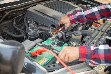 Adam uzun mesafeler kat etmeden önce düzgün ve güvenli bir şekilde tamir etmek için aracın motorunu ve durumunu kontrol ediyor. Adam güvenli bir yere gitmeden önce arabanın ve motorun durumunu kontrol ediyor..