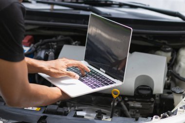Tamirci, araba içerisindeki kontrol kutusunun sistemini kontrol etmek için bilgisayar kullanıyor. Okunan verileri kontrol etmek ve araba arızalarını düzeltmek için bilgisayar kullanma kavramını kontrol ettikten sonra araba arızalarını düzeltmek için..