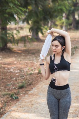 Güzel Asyalı kadın koşu sırasında kas hasarlarını azaltmak için kaslarını çalıştırmak için vücudunu ısıtıyor. Güzel Asyalı kadın koşuya hazırlanmak için kaslarını esnetiyor. .